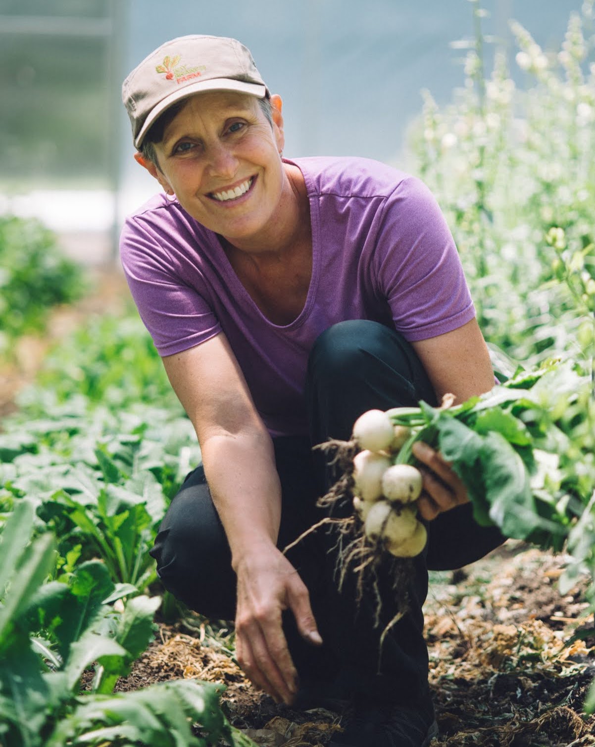 woman on a farm with a handful of turnips